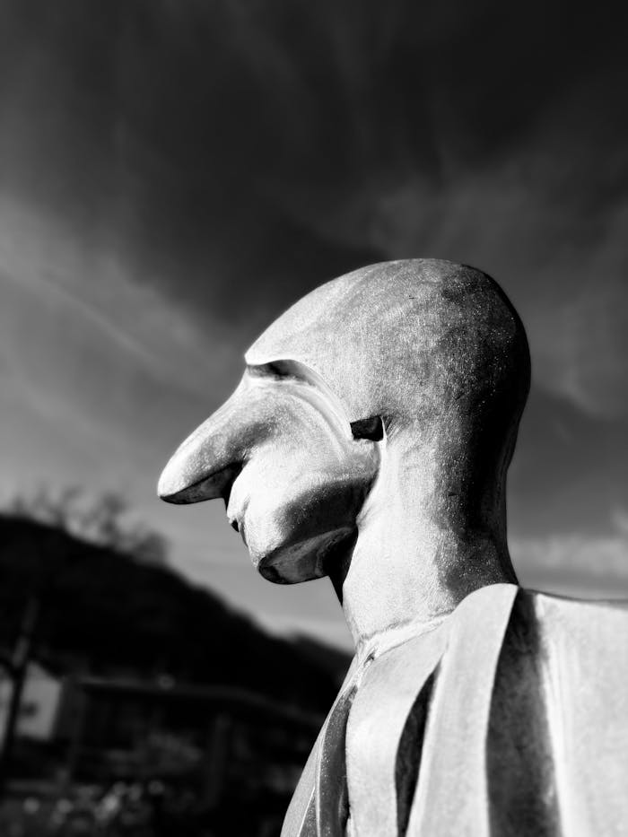 Artistic stone sculpture with abstract design in Bad Ragaz, Switzerland under a dynamic sky.